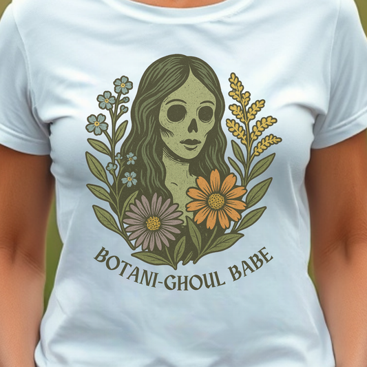 White t-shirt with a graphic design featuring a skeleton woman, flowers, and the text 'BOTANI-GOHUL BABE'.