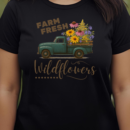 Black t-shirt with a graphic of a vintage truck carrying wildflowers and text 'Farm Fresh Wildflowers'.