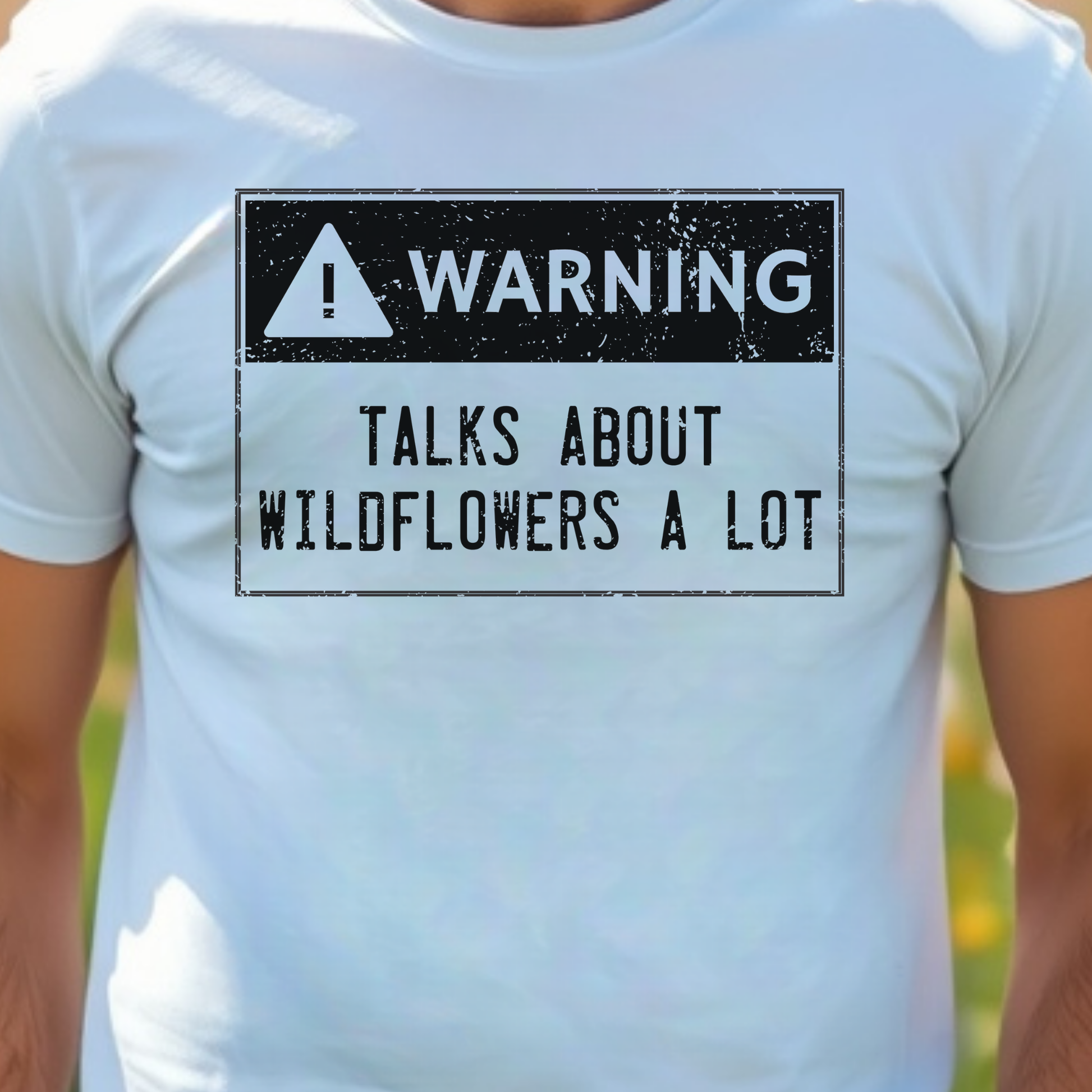 White t-shirt with a warning sign graphic and text 'WARNING: Talks about wildflowers a lot'.