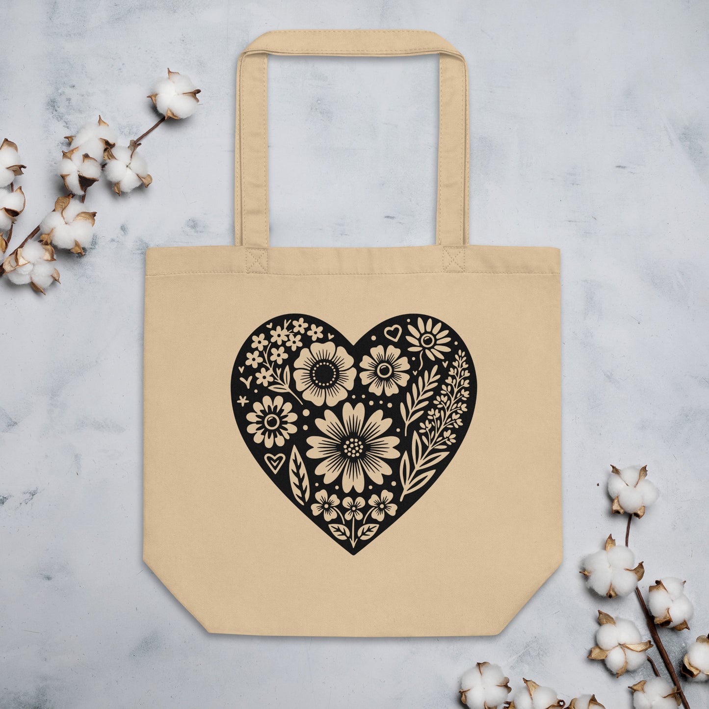 Beige tote bag with a black floral heart design.