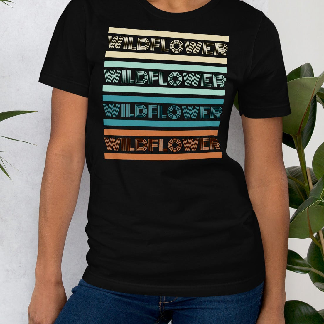 Black t-shirt with 'WILDFLOWER' text in colorful stripes.