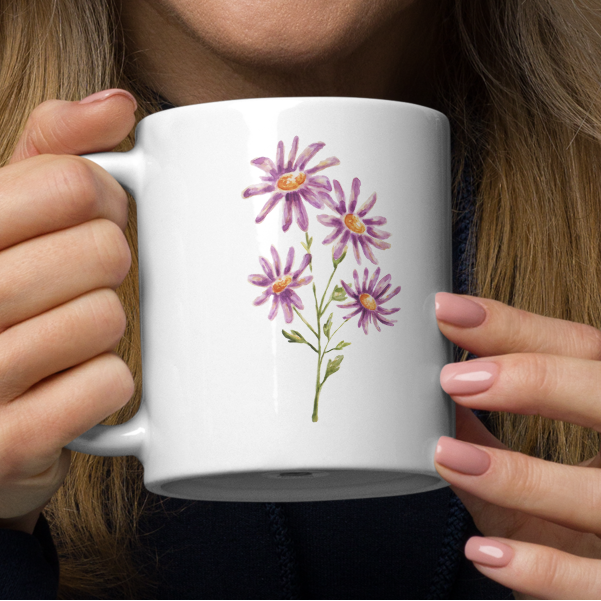Woman holding a white mug with floral design.